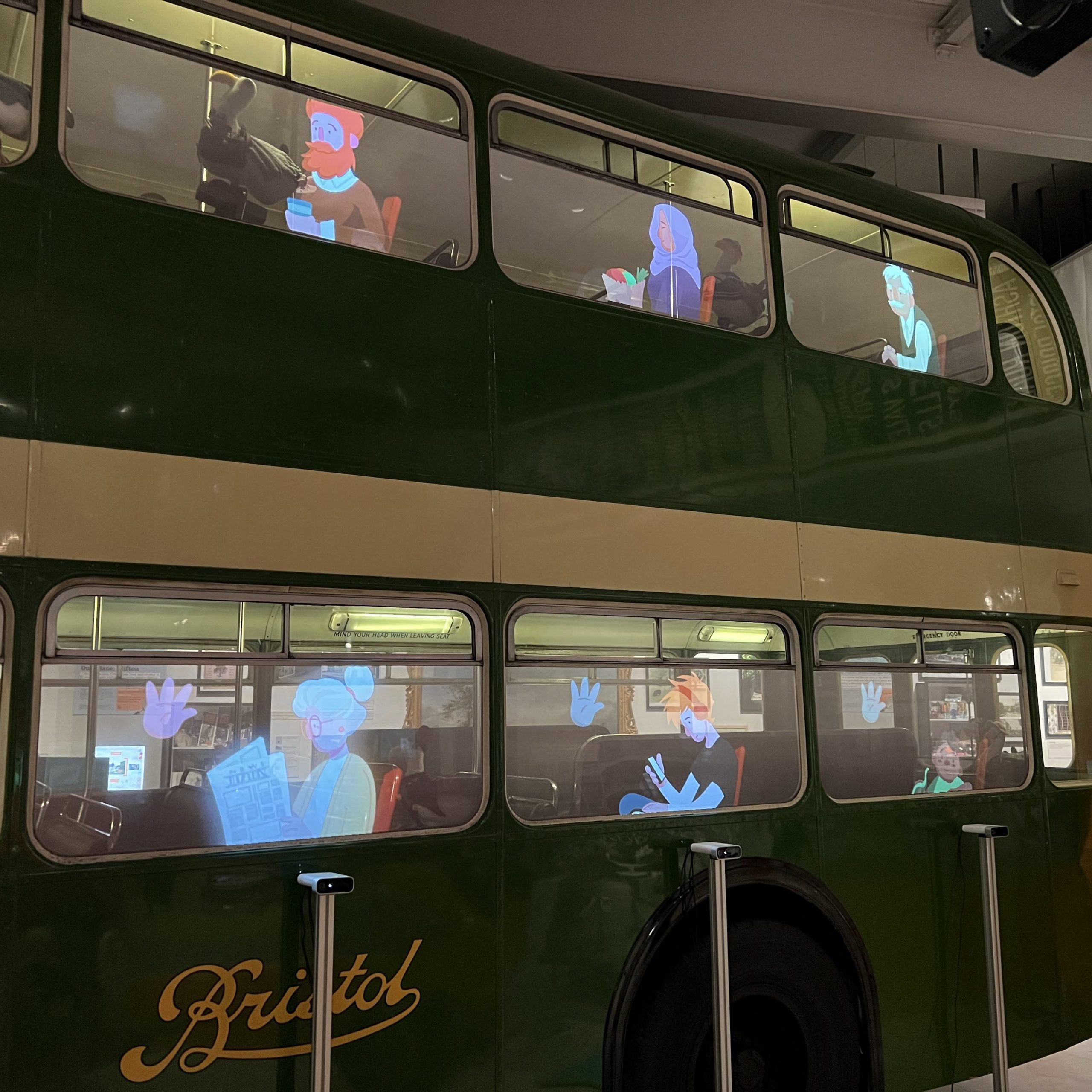 Side of Lodekka bus, 6 windows on show all with characters projected into them, a young man with beard top right, a woman with shopping and headdress top centre, old man top right, old woman with newspaper bottom left, teenager with phone bottom centre and boy with dinosaur bottom right. 